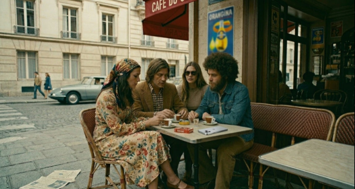 Scène de café vintage style années 70 avec anachronisme technologique – Magazine de jeux OTIOR.